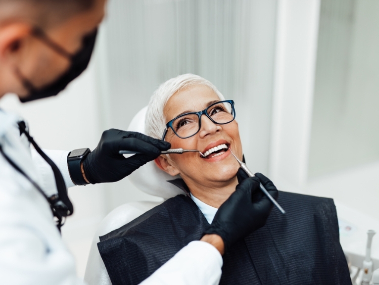 A smiling woman receives dental care