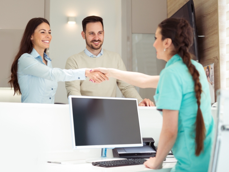 A dental nurse with happy dental patients