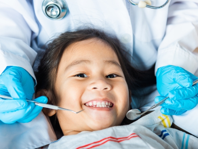 A happy child being inspected by a dentist