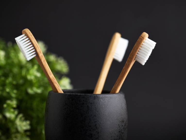 Eco-friendly bamboo toothbrushes in a cup.