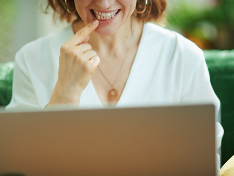 A woman has a teledentistry appointment via a laptop