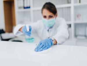 A dentist disinfects a work surface