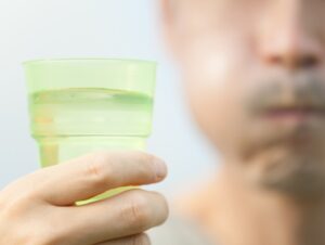 A man using mouthwash in a dental practice